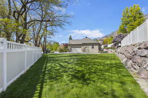 View of yard with an attached garage and a fenced backyard
