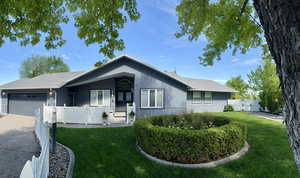 Ranch-style house featuring an attached garage, driveway, and french doors