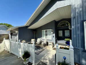 Doorway to property featuring french doors, fence, and a garage