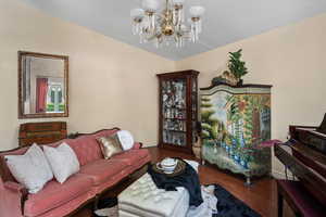 Living room featuring a chandelier, baseboards, and wood finished floors