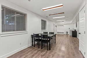 Dining room featuring wood finished floors, baseboards, and washer / dryer