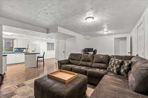 Living room featuring light wood-style flooring and baseboards