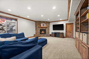 Living area with crown molding, recessed lighting, light colored carpet, a fireplace, and baseboards