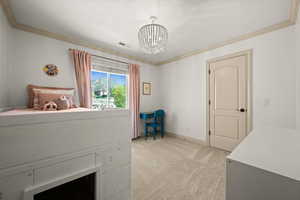 Bedroom with a chandelier, light carpet, ornamental molding, and baseboards