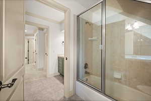Bathroom with combined bath / shower with glass door, crown molding, vanity, tile patterned floors, and baseboards
