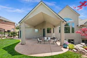 Back of house with stucco siding, outdoor lounge area, and a patio