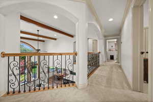 Hallway with carpet flooring, recessed lighting, arched walkways, baseboards, and beam ceiling