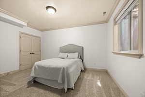 Bedroom with carpet floors, ornamental molding, and baseboards
