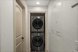 Laundry area with stacked washer and clothes dryer