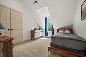 Carpeted bedroom featuring lofted ceiling and baseboards
