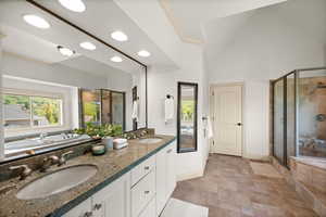 Full bath featuring a shower stall, baseboards, stone finish flooring, double vanity, and recessed lighting