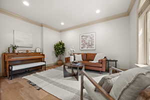 Living room featuring crown molding, light wood-type flooring, recessed lighting, and baseboards