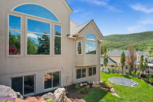 Rear view of property with stucco siding and a mountain view