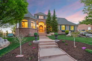 French provincial home with brick siding and a shingled roof