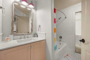 Full bathroom with crown molding, shower / bathtub combination with curtain, vanity, and tile patterned floors