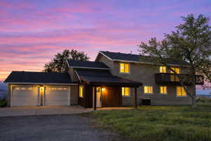 Traditional-style home featuring a garage, driveway, and a front yard