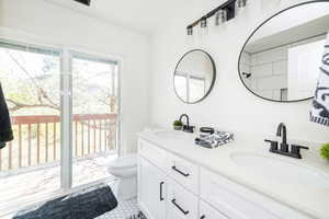 Full bathroom featuring double vanity and toilet