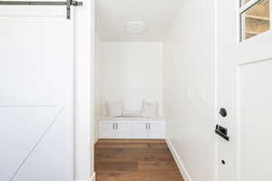 Mudroom featuring a barn door and dark wood-style floors