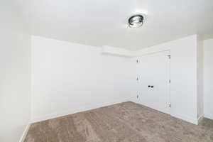 Unfurnished bedroom with carpet flooring, baseboards, and a closet
