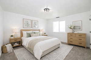 Carpeted bedroom featuring baseboards and a textured ceiling