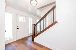 Entryway with stairs and wood finished floors