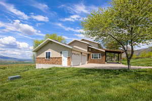 View of front of house with a mountain view, brick siding, a front lawn, and an attached garage
