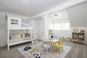 Bedroom featuring light colored carpet and a textured ceiling