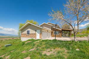 View of front of property with brick siding, an attached garage, a mountain view, and a front yard