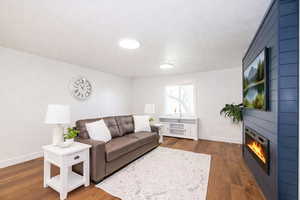 Living area with dark wood-style flooring and a textured ceiling