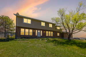 Back of house featuring a chimney and brick siding