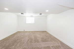 Spare room featuring light carpet, baseboards, and recessed lighting
