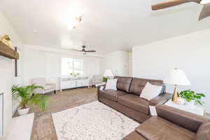 Carpeted living room with a ceiling fan