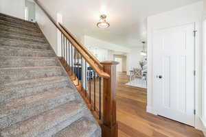 Staircase with wood finished floors and baseboards