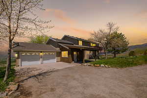 View of front of home featuring driveway, a shingled roof, a garage, board and batten siding, and a porch