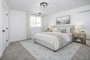 Bedroom featuring carpet flooring and a textured ceiling