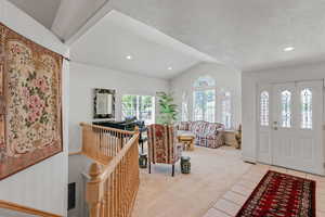 Foyer with vaulted ceiling, light colored carpet, light tile patterned floors, recessed lighting, and baseboards