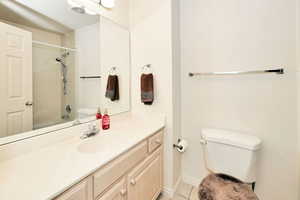 Full bath featuring toilet, vanity, tile patterned flooring,  shower combination, and baseboards