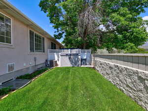 View of yard featuring central AC unit and a gate