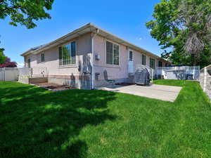 Rear view of house with stucco siding and a patio area