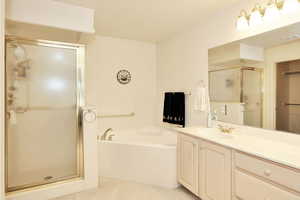 Full bathroom with a shower stall, a garden tub, and vanity