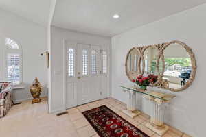 Entryway featuring recessed lighting, baseboards, and light tile patterned floors