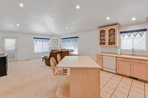 Kitchen featuring dishwasher, light brown cabinetry, recessed lighting, a sink, and light countertops