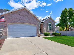 View of front of property with brick siding, concrete driveway, and an attached garage