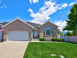 View of front facade with brick siding, an attached garage, and concrete driveway
