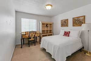 Bedroom featuring light carpet and baseboards
