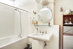 Bathroom with tiled shower / bath combo and a sink