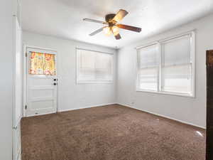Unfurnished room with a ceiling fan, carpet, baseboards, and a textured ceiling