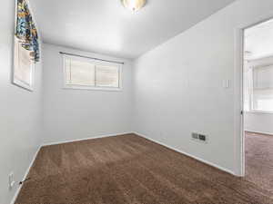 Carpeted spare room with baseboards
