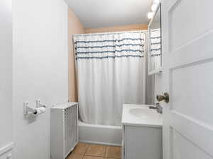 Full bathroom with tile patterned floors, vanity, and shower / bath combination with curtain