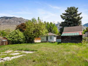 View of yard with a mountain view, a storage unit, and an outdoor structure